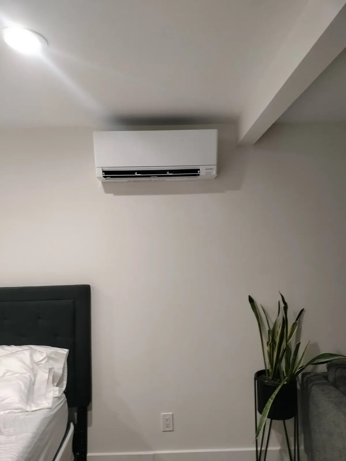 Mitsubishi ductless mini-split head mounted in a Phoenix bedroom for quiet, zoned cooling