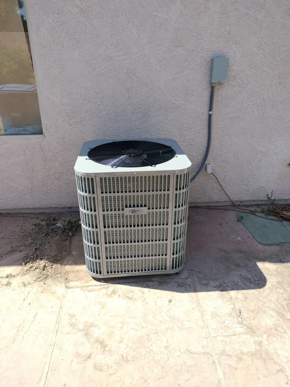 Split-system A/C condenser installed on a concrete pad beside a Phoenix home