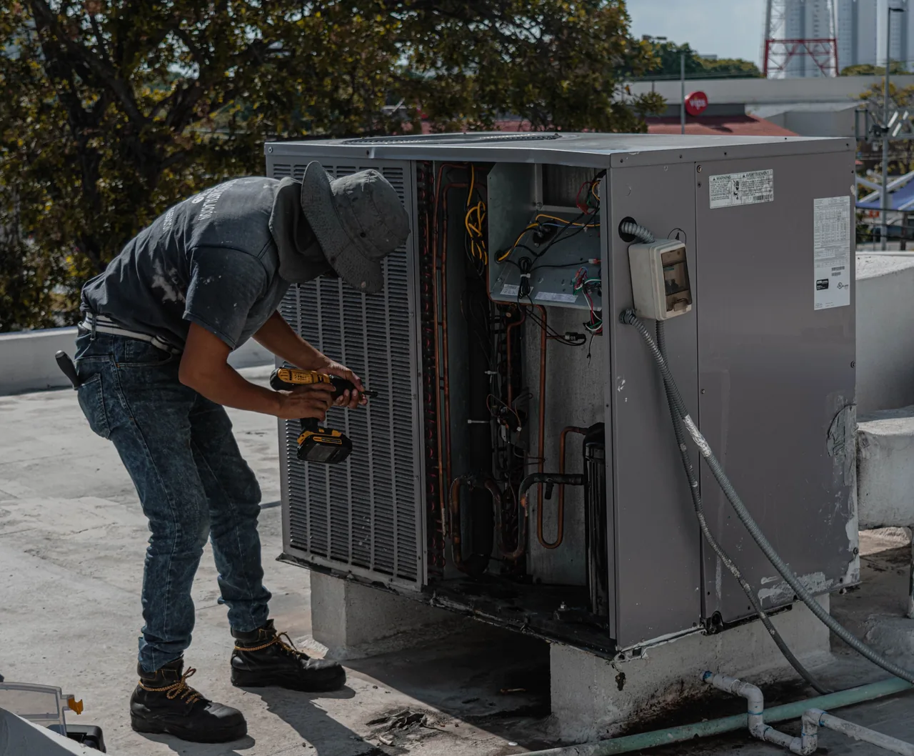 HVAC technician servicing an outdoor AC condenser unit in the Phoenix heat